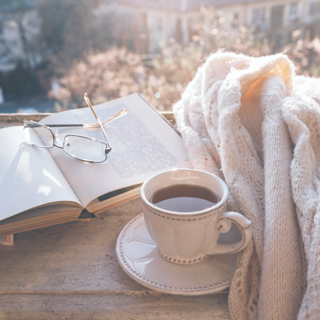 Photo d'une tasse de thé avec un livre et un pull en laine