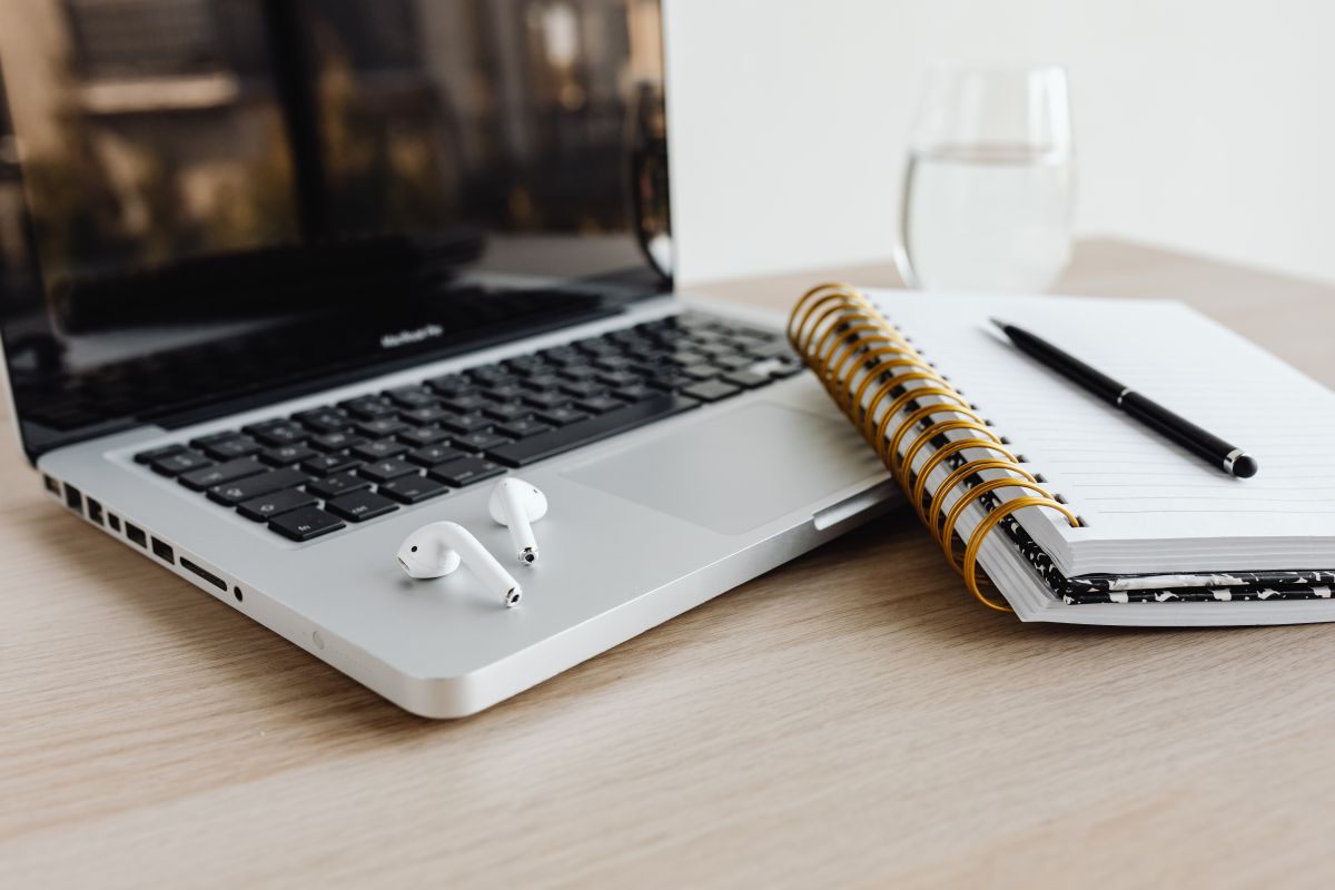 Photo d'un ordinateur portable ouvert avec un carnet et un stylo