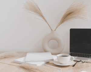 Photo d'un bureau avec un carnet, une tasse et un ordinateur