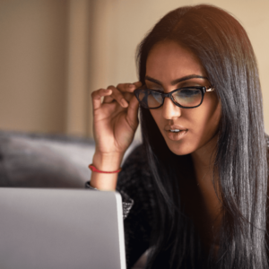 Photo d'une femme assise à son bureau qui regarde son ordinateur