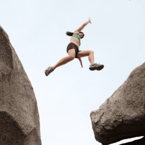 Femme entrain de sauter par-dessus un caillou