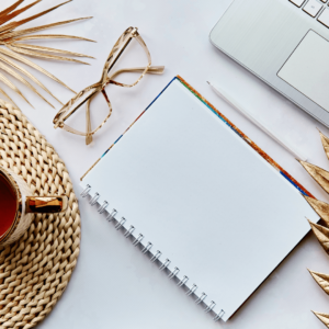 Un carnet posé sur un bureau avec une paire de lunettes