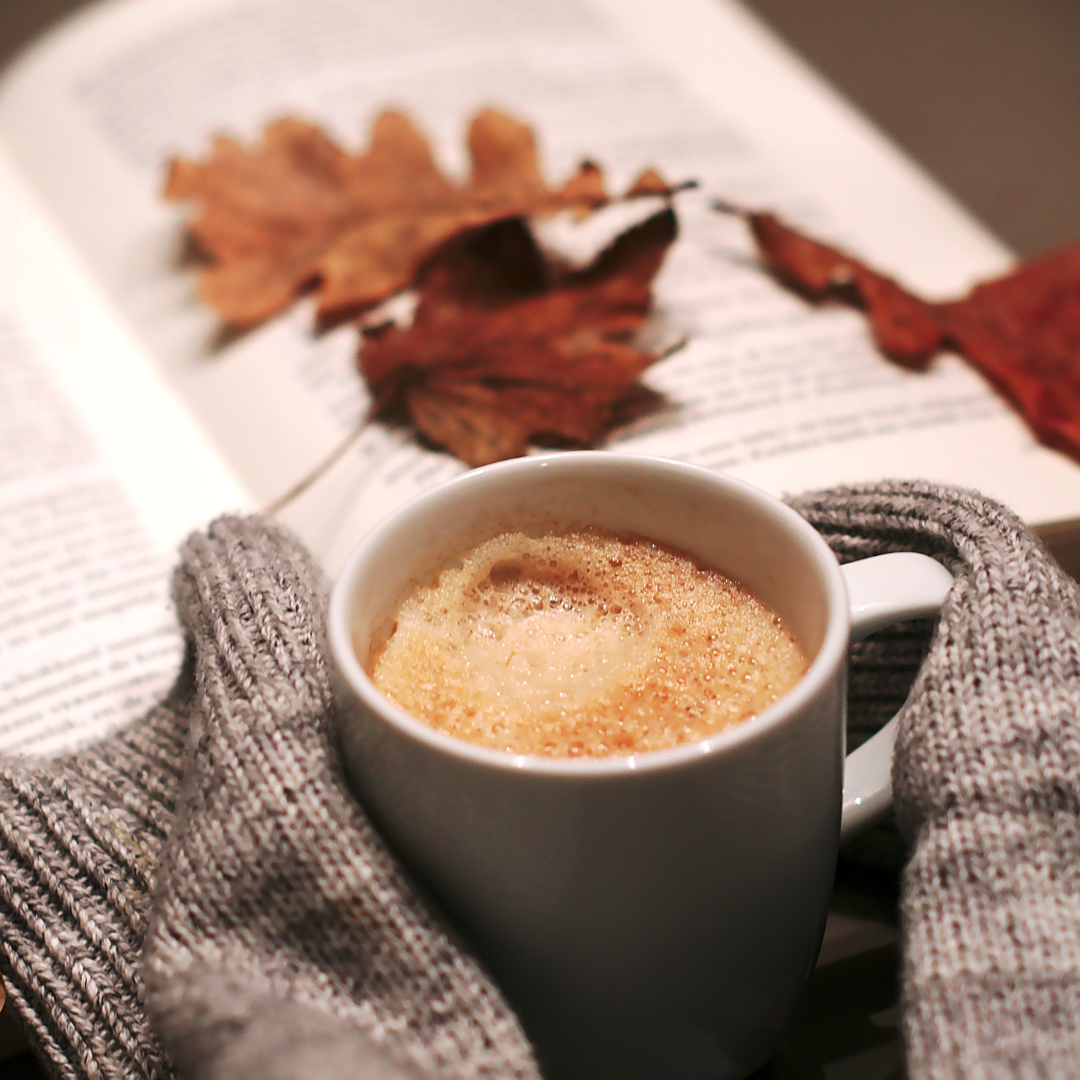 Livre ouvert avec une tasse de thé posée à côté