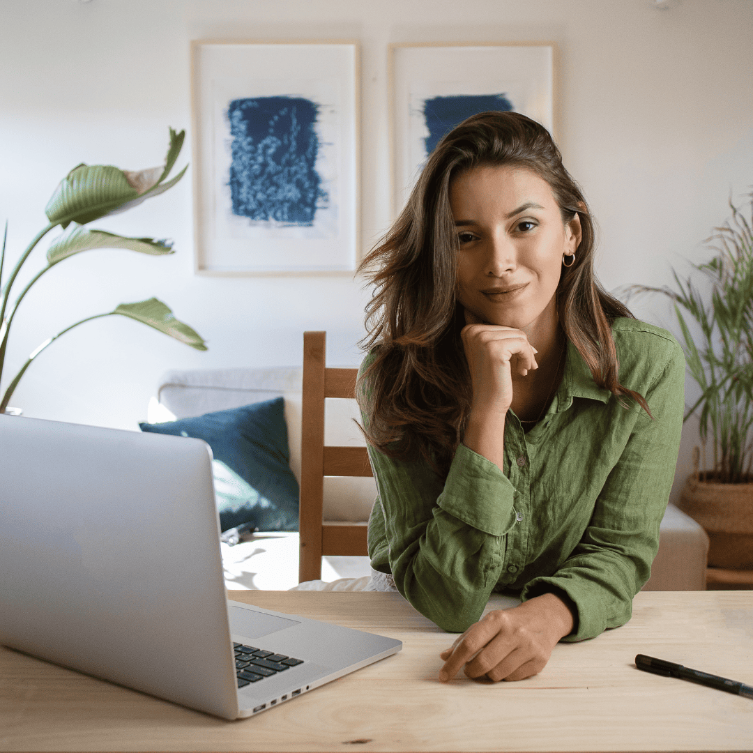 Photo de présentation de l'article de Blog : Choisir le bon Business Model selon son type énergétique en Human Design. C'est une femme qui regarde l'objectif avec un ordinateur portable ouvert à côté d'elle